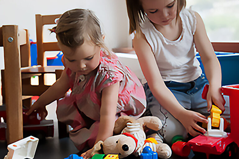 Zwei Kinder, die im Wartezimmer mit Spielzeug spielen