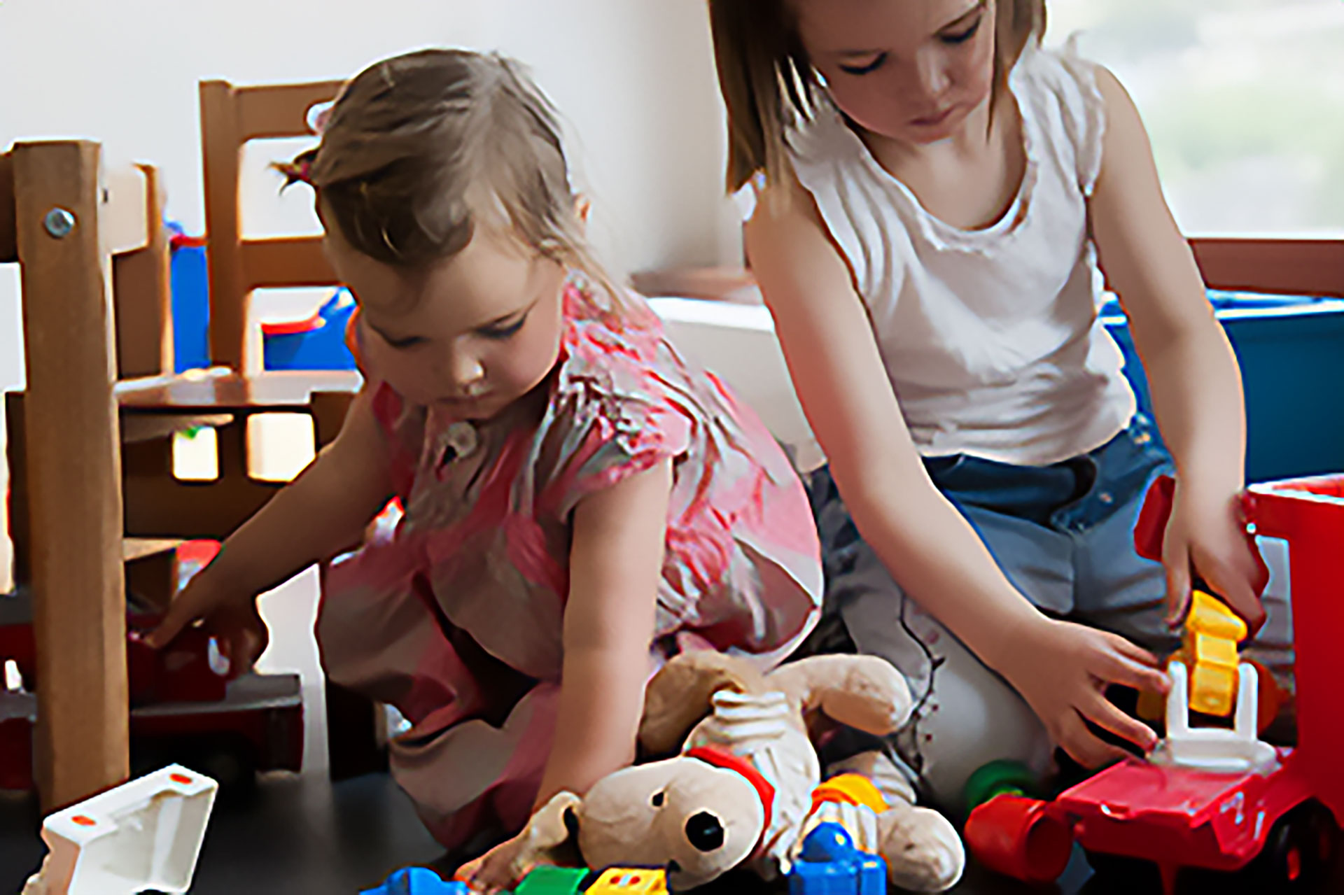 Zwei Kinder, die im Wartezimmer mit Spielzeug spielen